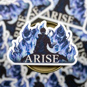 May include: A sticker featuring a silhouette of a figure with blue flames and the word "ARISE". The design is set against a background of similar stickers. The sticker has a white border and a glossy finish.
