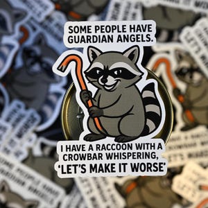 May include: A sticker featuring a cartoon raccoon holding an orange crowbar. The raccoon has a black mask and striped tail. Text reads, "SOME PEOPLE HAVE GUARDIAN ANGELS. I HAVE A RACCOON WITH A CROWBAR WHISPERING, 'LET'S MAKE IT WORSE'"