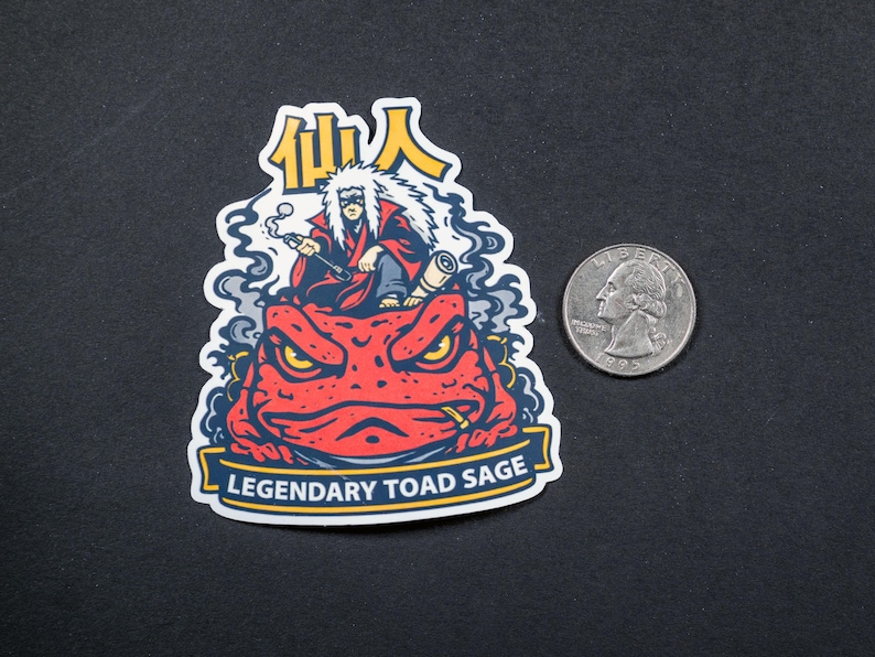 Puede incluir: Una pegatina con una ilustraci&oacute;n de dibujos animados de una figura con una t&uacute;nica roja sentada sobre un sapo rojo. La pegatina tiene el texto "Legendary Toad Sage" y caracteres japoneses. Hay una moneda al lado.