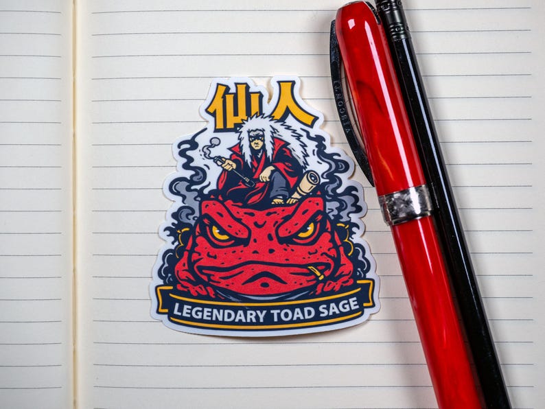 Puede incluir: Una pegatina con un sapo rojo con ojos amarillos y un personaje fumando en pipa. El personaje lleva una t&uacute;nica roja y tiene el pelo blanco. La pegatina tiene el texto "Legendary Toad Sage" y caracteres japoneses.