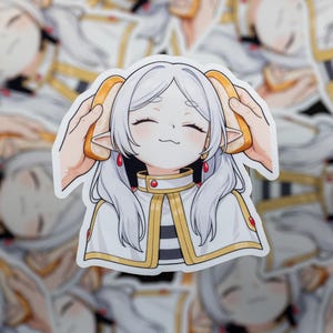 May include: A sticker featuring an anime-style character with white hair and a white and gold outfit. The character has bread slices held to their ears. The sticker has a glossy finish and is surrounded by other stickers.