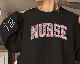May include: Black sweatshirt with a floral print of the word "NURSE" in pink.