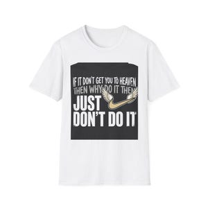 Puede incluir: Una camiseta blanca de manga corta con un gráfico rectangular negro en el pecho. El gráfico muestra el texto IF IT DON'T GET YOU TO HEAVEN THEN WHY DO IT THEN JUST DON'T DO IT junto a un logotipo de swoosh dorado con alas blancas.