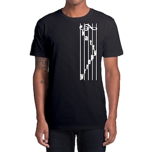 Può includere: T-shirt nero con un design a pentagramma bianco. Il design include una chiave di violino e le parole "katty perry" scritte verticalmente lungo le linee del pentagramma. Una t-shirt casual per tutti i giorni.