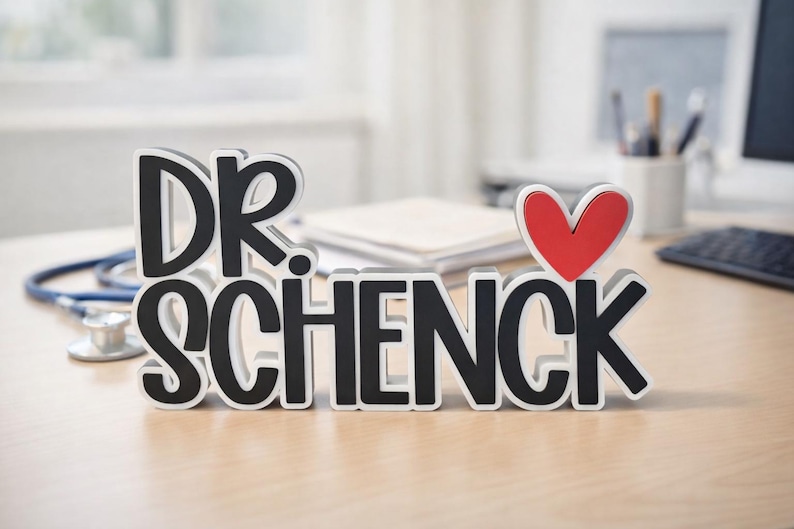 Puede incluir: Un letrero independiente que presenta el texto negro DR. SCHENCK con un s&iacute;mbolo de coraz&oacute;n rojo colocado sobre la letra K. Las letras tienen un borde blanco y un contorno negro grueso, creando un efecto dimensional en la superficie.