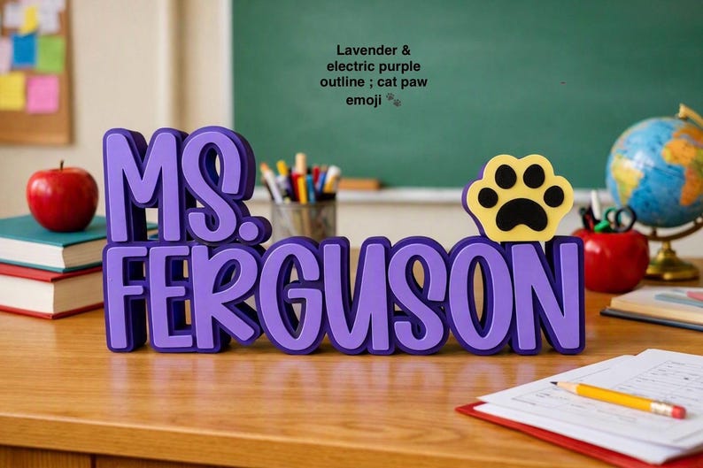 Puede incluir: Un letrero de escritorio personalizado con el nombre MS. FERGUSON en letras superpuestas de color lavanda y morado el&eacute;ctrico. El letrero incluye un icono de emoji de pata de gato amarillo y negro a la derecha. El texto tiene una fuente redondeada.