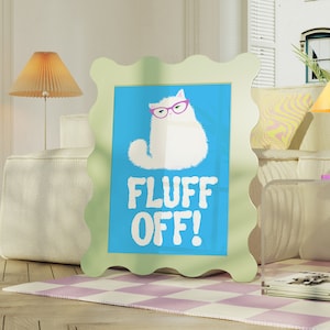 May include: A light green frame with a wavy edge surrounds a blue background with a white cat wearing pink glasses. The cat is looking to the right and the text "FLUFF OFF!" is written in black below the cat.