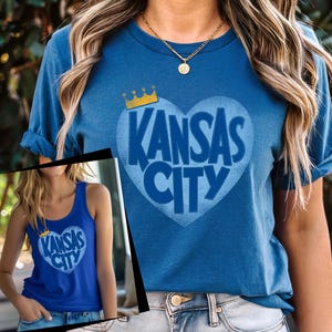 May include: A blue t-shirt with a blue heart graphic that says "Kansas City" in white letters. A gold crown sits above the heart.