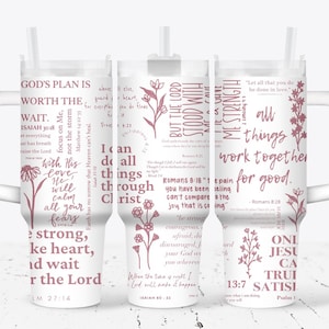 May include: White tumbler with a pink handle and lid. The tumbler has a pink floral design and inspirational quotes with bible verses. The quotes include "God's plan is worth the wait", "But the Lord stood with me strength", and "All things work together for good".