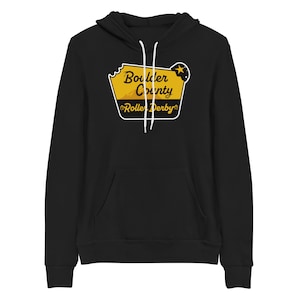May include: Black hoodie with a yellow and white graphic of a sign that says "Boulder County Roller Derby".
