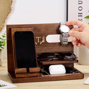 May include: A wooden organiser with compartments for a phone, watch, glasses, and other small items. The organiser has a personalised inscription with the letter "T" and a deer antler design.