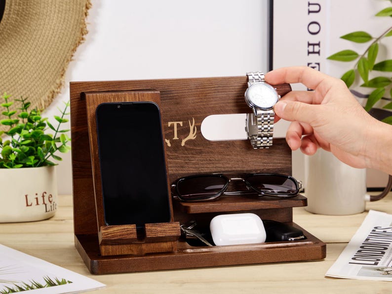 May include: A wooden organiser with compartments for a phone, watch, glasses, and other small items. The organiser has a personalised inscription with the letter "T" and a deer antler design.