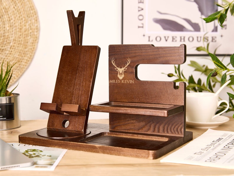 May include: Wooden phone stand with a phone holder, watch holder, and a small tray. The stand is engraved with a deer silhouette and the text "MILES KEVIN".