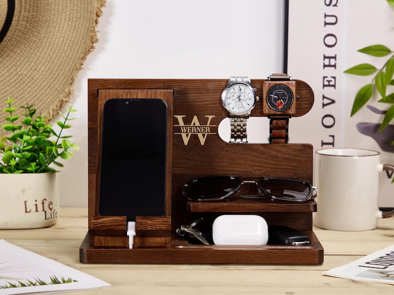 May include: A wooden organiser with a phone charging station, watch holders, and a space for sunglasses. The organiser is personalised with the name "Werner".