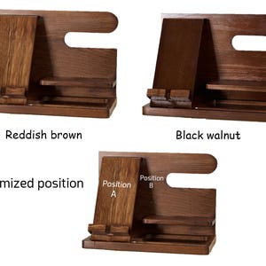 May include: Wooden phone stand with two positions for holding a phone, labelled "Position A" and "Position B". The stand is available in reddish brown and black walnut.