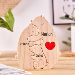 May include: Wooden bear family puzzle with the names Valerie, Marlon, and Juliet engraved on it. The bears are hugging each other and there is a red heart in the middle.