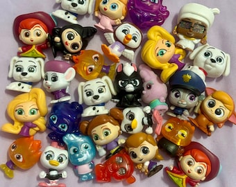 May include: A collection of 25 colorful plastic figurines, featuring characters from popular children's movies and TV shows. The figurines are small, about 2 inches tall, and are made of a variety of materials, including plastic, rubber, and fabric. The figurines are all in different poses and expressions, and some are holding props, such as a microphone, a guitar, and a baseball bat.