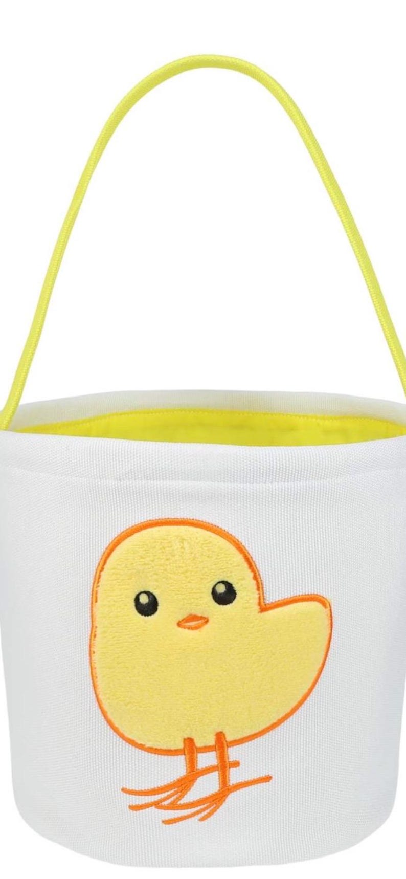 May include: White Easter basket with a yellow chick design. The bucket has a yellow handle and a yellow interior lining. The chick is yellow with an orange outline and orange feet.