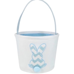 May include: White Easter basket with a light blue interior and handle. A light blue and white chevron pattern bunny is embroidered on the front, with a small blue pom-pom tail.