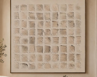 May include: A square wall art piece featuring a grid of raised, textured squares in shades of cream and beige. The artwork is framed in a thin, dark metal border and displays a repeating pattern of swirling, impasto-style brushstrokes.