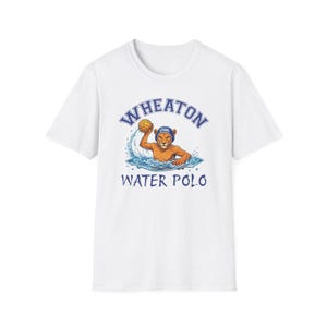 May include: A white short-sleeve t-shirt featuring a graphic of a lion wearing a blue water polo cap with the text LYONS. The lion is in water, holding a yellow ball. The text WHEATON is arched above and WATER POLO is printed below the graphic.