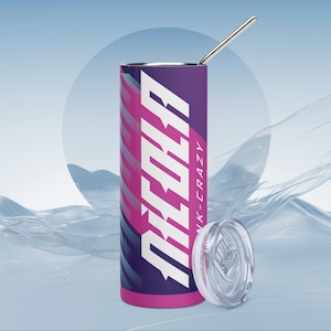 Puede incluir: Un vaso alto y cilíndrico con un diseño morado y rosa, una pajita plateada y una tapa transparente. El vaso presenta la palabra "REOLA" en blanco, con "PINK-CRAZY" debajo. El diseño tiene un patrón ondulado.