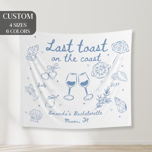 May include: White bachelorette party backdrop with blue text that reads "Last toast on the coast" and blue illustrations of wine glasses, lemons, seashells, and other beach-themed items. The text also includes "July", "2024", "Amanda's Bachelorette", and "Miami, Fl."