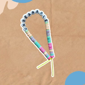 May include: A colourful beaded necklace with the word "UNBEARABLE" spelled out in white letters on the beads.