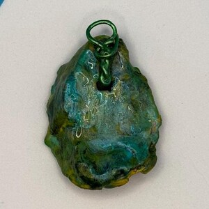 May include: A green and blue agate pendant with a green wire loop for hanging.