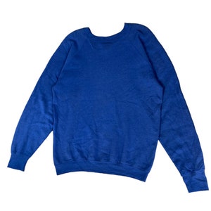 May include: A blue long-sleeved sweatshirt with a crew neck.