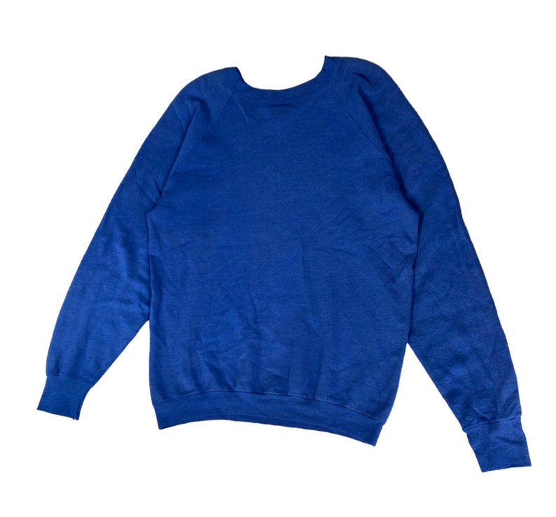 May include: A blue long-sleeved sweatshirt with a crew neck.