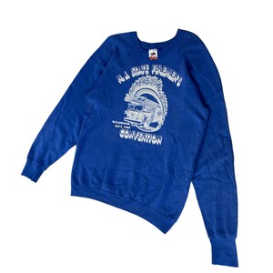 May include: A blue sweatshirt with a white graphic of a fire truck and the text "N.J. State Firemen's Convention" and "Wildwood Sept. 1989".