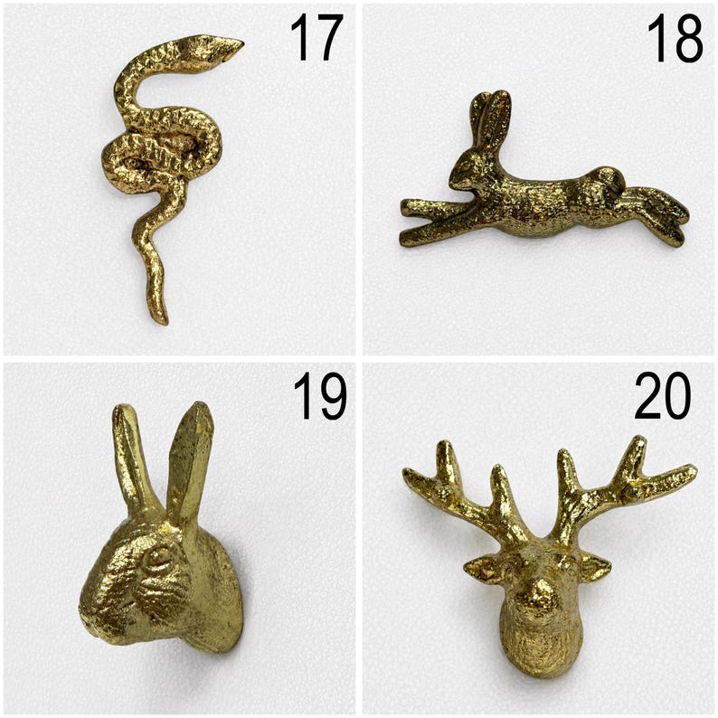 May include: A collection of four gold-toned metal decorative wall hooks labelled 17 through 20. The designs include a coiled snake, a leaping rabbit, a rabbit head, and a deer head with antlers, all featuring a textured, metallic finish.