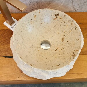 Vista dall’alto del lavabo in marmo beige con vasca interna levigata e inclusioni minerali naturali