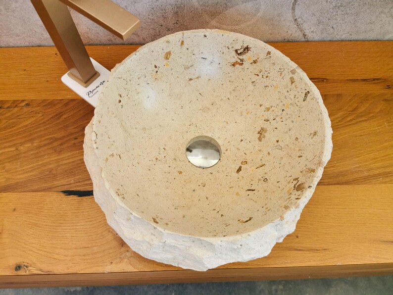 Vista dall’alto del lavabo in marmo beige con vasca interna levigata e inclusioni minerali naturali