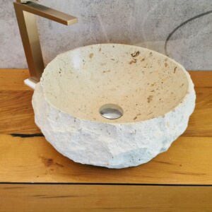 Lavandino da appoggio in marmo naturale beige visto dal lato destro con superficie materica