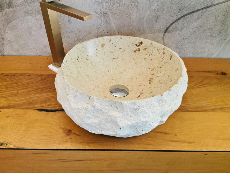 Lavandino da appoggio in marmo naturale beige visto dal lato destro con superficie materica