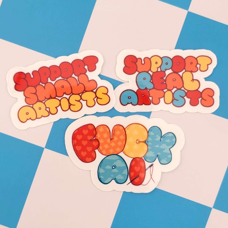 Puede incluir: Tres pegatinas coloridas con letras de burbujas sobre un fondo a cuadros azul y blanco. Las pegatinas dicen "SUPPORT SMALL ARTISTS", "SUPPORT REAL ARTISTS" y "FUCK ALL". Las letras son rojas, naranjas, amarillas y azules.