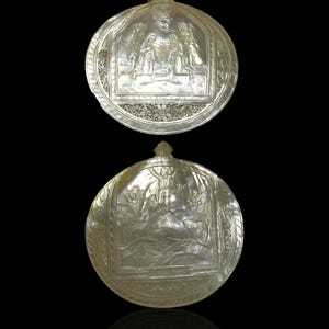 Può includere: Due ciondoli rotondi in madreperla bianca con intagli intricati. Il ciondolo superiore presenta una scena della Natività, mentre il ciondolo inferiore rappresenta una scena dell'Assunzione della Vergine Maria.