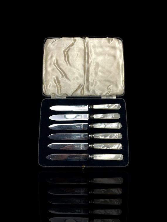 A high quality mother of pearl and stainless steel set of 6 butter knives. Circa 1920s. Cased.