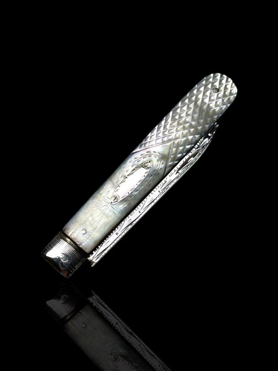 A finely hand-carved mother of pearl antique folding pocket knife. Made in 1867, England. With presentation case.