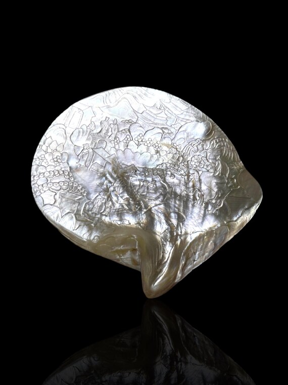A Qing dynasty hand-carved pearl shell. Late 1800s. With stand.