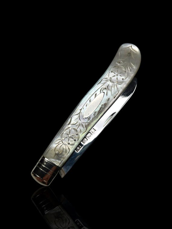 A fine antique gentleman's silver fruit knife with a beautifully carved mother-of-pearl handle and sterling silver blade.
