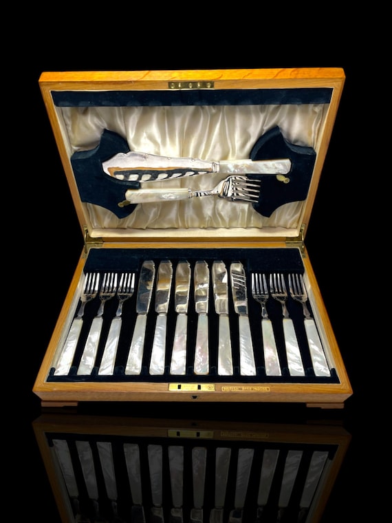 A vintage set of mother of pearl and silver plate fish knives and forks. Additional serving set. Circa 1900. Cased.