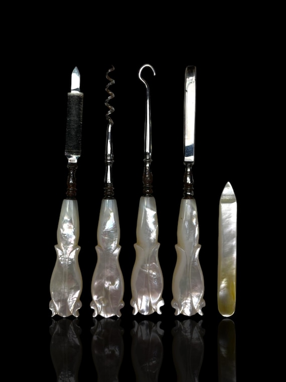 A mother of pearl travelling vanity set. Cased.