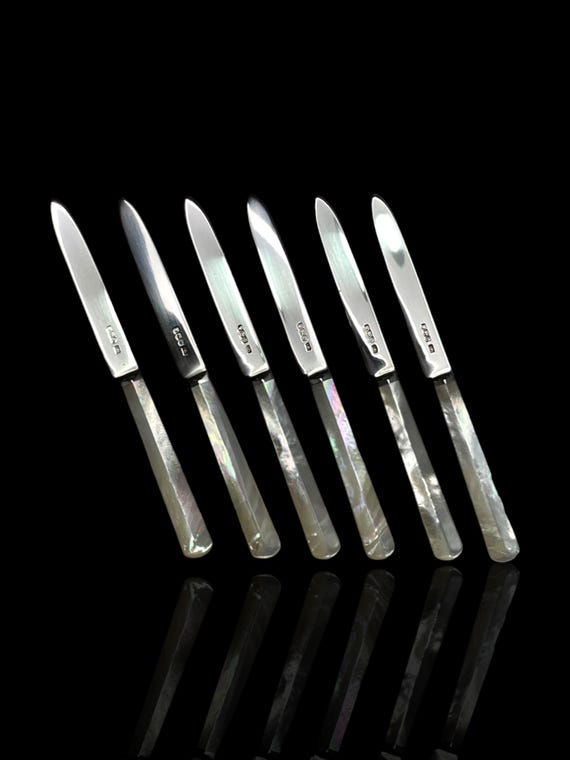A superb art deco set of sterling silver and mother of pearl butter knives. Cased. Made in 1925 by English silversmith Atkin Brothers.