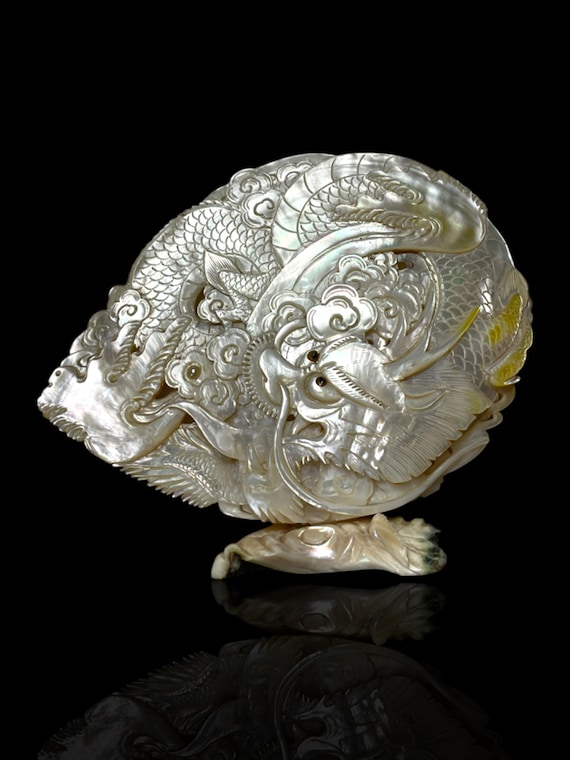 A large Japanese-carved Australian pearl shell depicting a dragon. An Akoya pearl set into the shell. Circa 1970s.