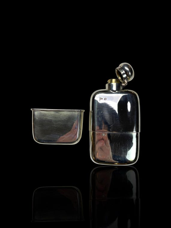 A fine and large antique English sterling silver hip flask, crafted by the renowned firm Walker & Hall of Sheffield in 1911.