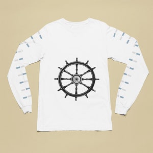 Puede incluir: Camiseta blanca de manga larga con un gráfico de timón de barco en blanco y negro en la parte delantera. Las mangas tienen un patrón de rayas blancas y azules alternas.