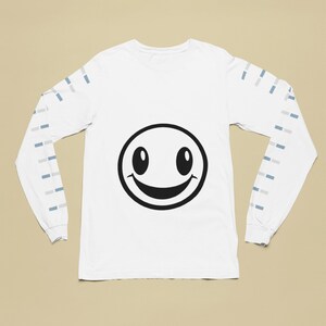 Op de afbeelding: Witte longsleeve t-shirt met een zwarte smiley-gezichtsgrafiek en blauwe en grijze strepen op de mouwen.
